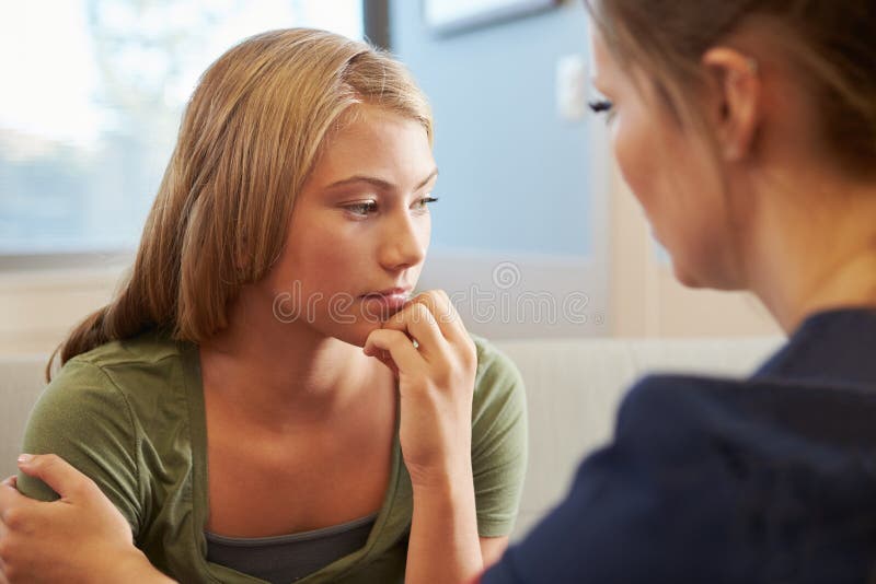 Nurse Treating Teenage Girl Suffering With Depression. Nurse Treating Teenage Girl Suffering With Depression