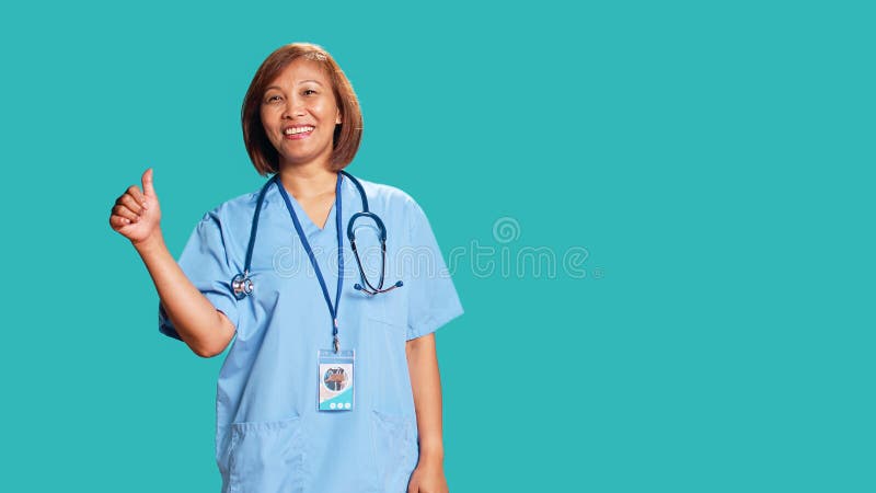 Krankenschwester zeigt Daumen auf Schild stockbilder