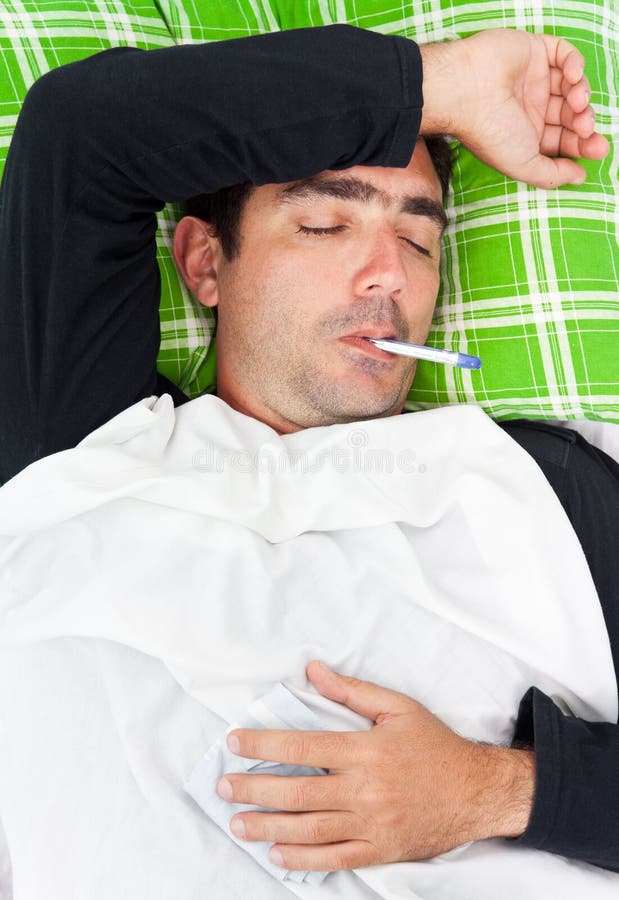 Portrait of a sick hispanic man laying in bed with a thermometer in his mouth and his eyes closed. Portrait of a sick hispanic man laying in bed with a thermometer in his mouth and his eyes closed