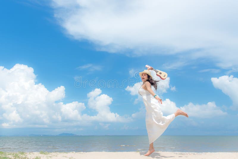 Krasnodar Gegend, Katya Riechende asiatische Frauen, die eine Ukulele auf dem Strand sich entspannen und spielen, stockfotos Krasnodar Gegend, Katya Riechende asiatische Frauen, die eine Ukulele auf dem Strand sich entspannen und spielen, stockfotos