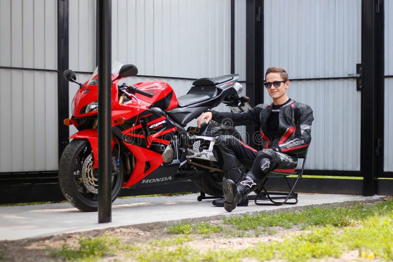 KRASNOYARSK, RUSIA - 15 de julio de 2019: Motorista hermoso en engranaje lleno y casco en Honda rojo y negro 2005 CBR 600 RR PC37 imagen de archivo KRASNOYARSK, RUSIA - 15 de julio de 2019: Motorista hermoso en engranaje lleno y casco en Honda rojo y negro 2005 CBR 600 RR PC37 imagen de archivo