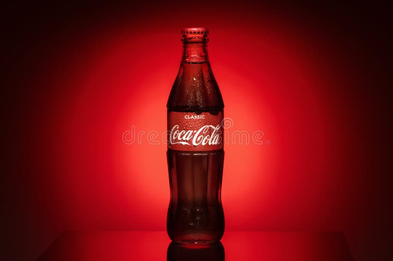 Krasnoyarsk, Ρωσία, στις 29 Ιουνίου 2019: Κλασικός της Coca-Cola σε ένα μπουκάλι γυαλιού στα σκοτεινά τονισμένα ομιχλώδη κόκκινα στοκ φωτογραφίες Krasnoyarsk, Ρωσία, στις 29 Ιουνίου 2019: Κλασικός της Coca-Cola σε ένα μπουκάλι γυαλιού στα σκοτεινά τονισμένα ομιχλώδη κόκκινα στοκ φωτογραφίες