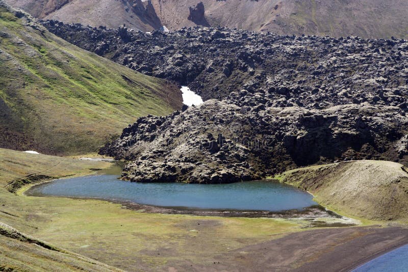 Krater jezioro przy Lak wulkanem z czarną lawą sourrounded niewygładzonymi górami, Iceland zdjęcia royalty free Krater jezioro przy Lak wulkanem z czarną lawą sourrounded niewygładzonymi górami, Iceland zdjęcia royalty free