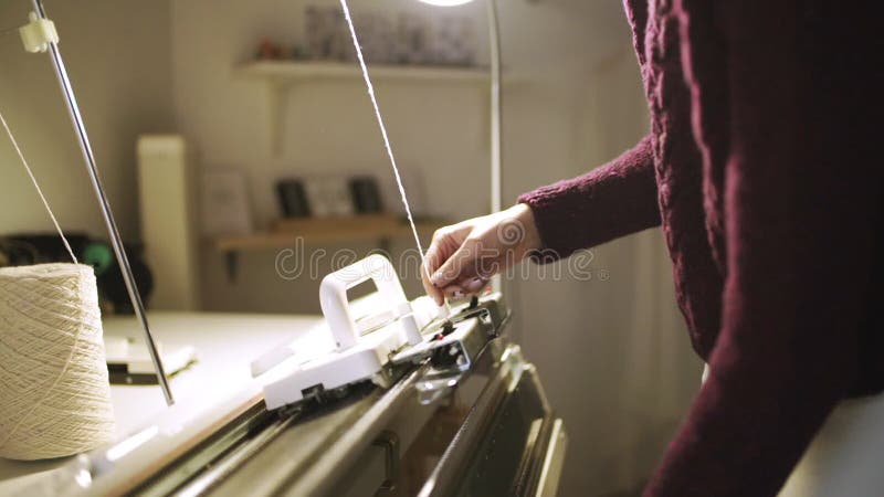 Kreative Frau, die Webstuhl für Arbeit in der Textilwerkstatt vorbereitet