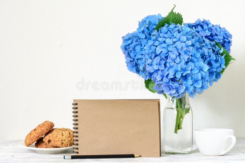 Kreativer Spott oben mit einem schönen Blumenstrauß von blauen Hortensieblumen, von Kaffeetasse, von Haferplätzchen und von leere lizenzfreie stockfotos Kreativer Spott oben mit einem schönen Blumenstrauß von blauen Hortensieblumen, von Kaffeetasse, von Haferplätzchen und von leere lizenzfreie stockfotos