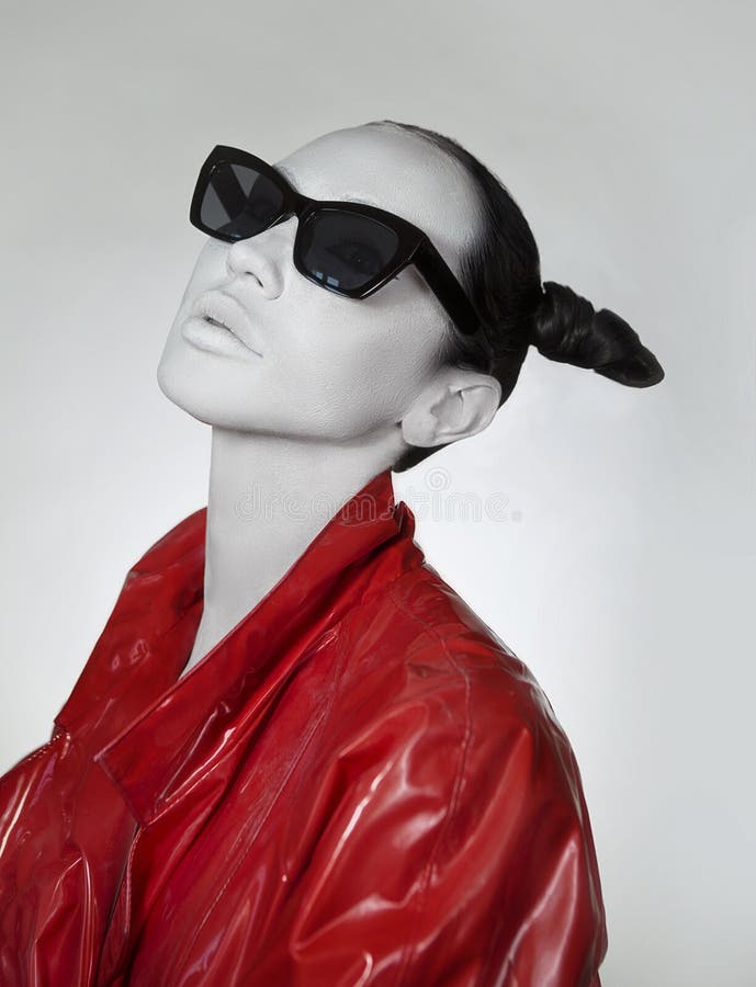 Kreativer Zauber Junge Frau im modernem rotem langem Lackregenmantel und -Sonnenbrille lizenzfreie stockfotos Kreativer Zauber Junge Frau im modernem rotem langem Lackregenmantel und -Sonnenbrille lizenzfreie stockfotos