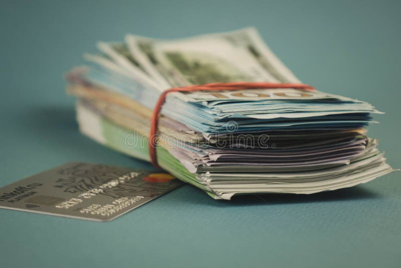 Kreditkarten und ein Bündel Geld auf einem einfachen blauen Hintergrund lizenzfreies stockfoto Kreditkarten und ein Bündel Geld auf einem einfachen blauen Hintergrund lizenzfreies stockfoto