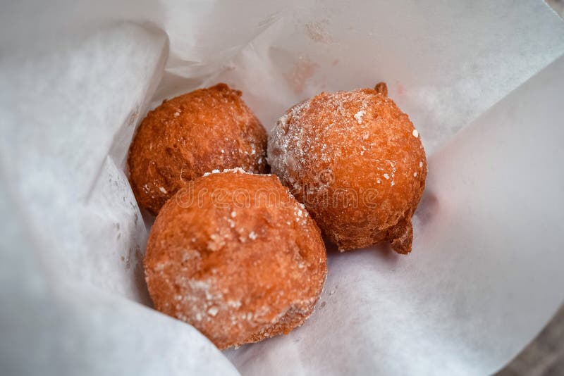 Kreukgefrituurde deegballen in papier, met suikerklontjes dicht stock afbeeldingen Kreukgefrituurde deegballen in papier, met suikerklontjes dicht stock afbeeldingen