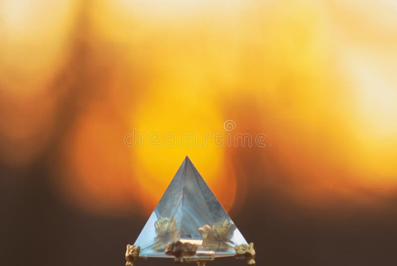 Kristallglaspyramide auf einem Hintergrund eines Sonnenuntergangs verwischte Sonne und Himmel für Entspannungsmeditation und -wei