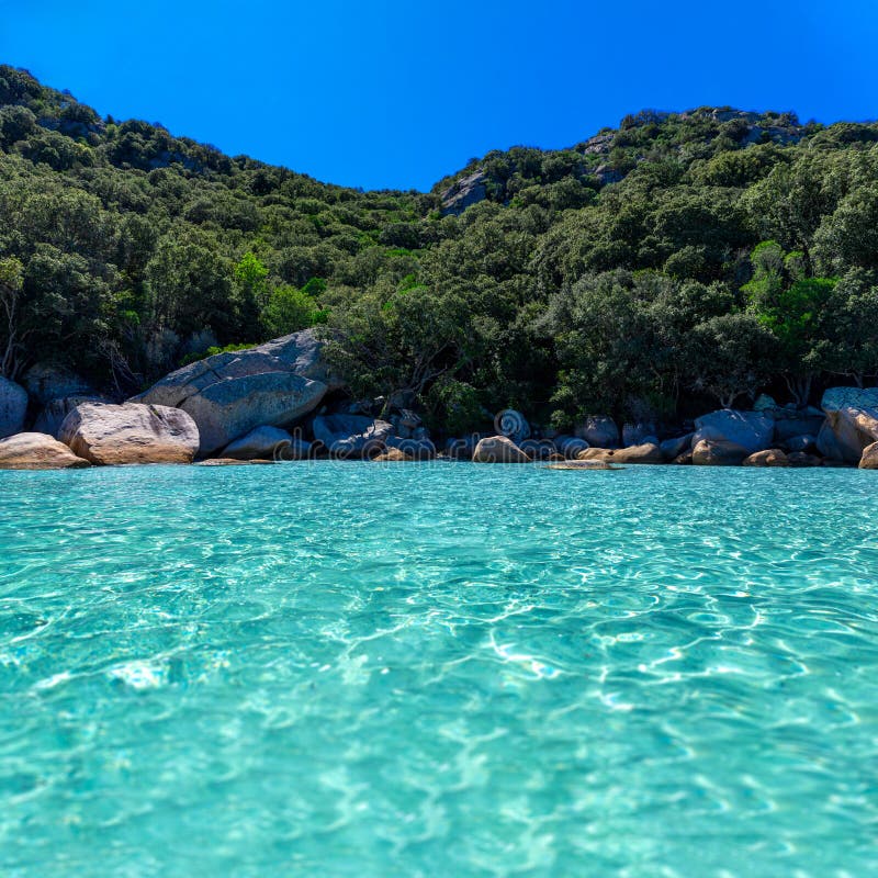 Kristallklares türkisfarbenes Wasser und große, glatte Felsen auf einem ruhigen Strand umgeben von Natur. ein idealer Ort zum Ents stockfoto