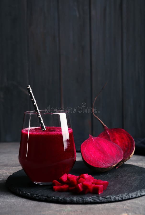 Slate plate with glass of beet smoothie on table, space for text. Slate plate with glass of beet smoothie on table, space for text