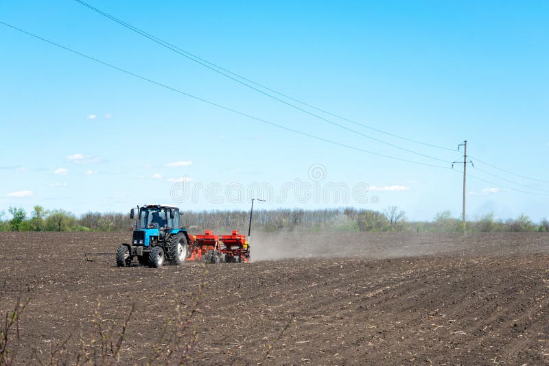 Kropivnitskiy, Ukraine 12 may, 2018: tractor sows corn on a plowed field on a sunny day. tractor seeding - sowing crops at