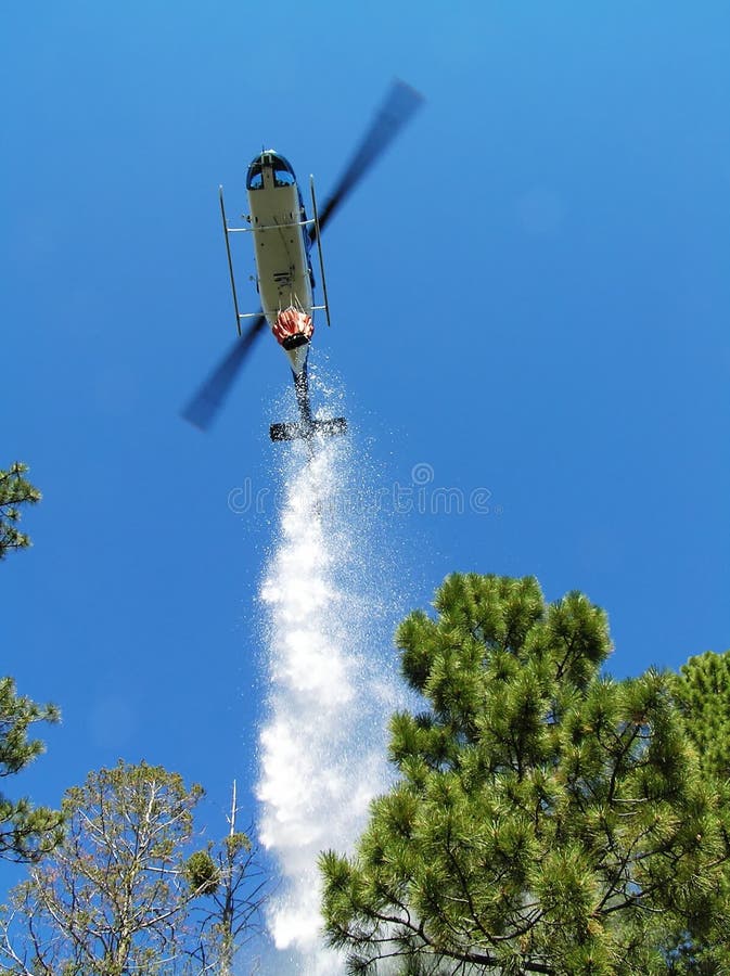 Firefighting helicopter dropping water on a forest fire. Firefighting helicopter dropping water on a forest fire.