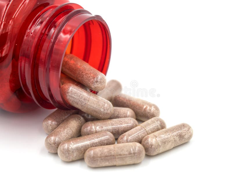 Kruidcapsules die uit een fles morsen stock foto Kruidcapsules die uit een fles morsen stock foto