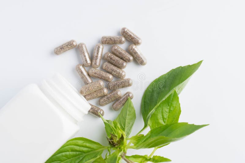 kruidcapsules die uit een geïsoleerde fles morsen royalty-vrije stock foto's kruidcapsules die uit een geïsoleerde fles morsen royalty-vrije stock foto's