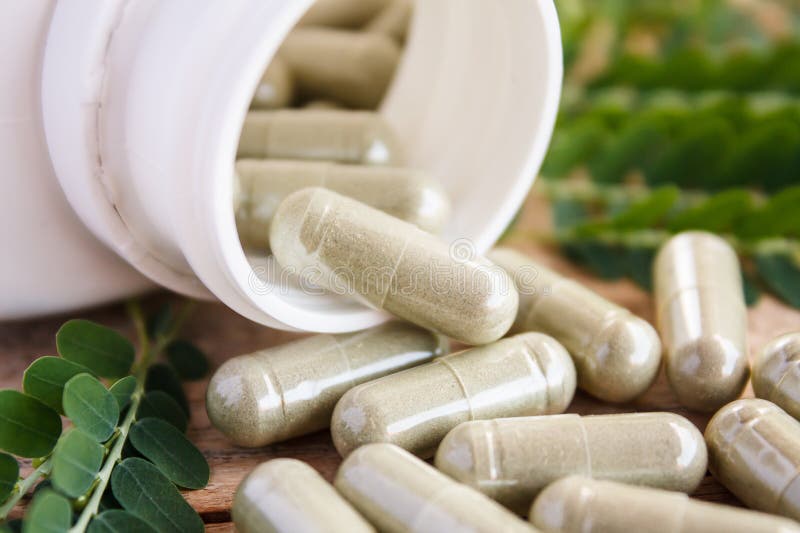 Kruidcapsules die uit fles morsen stock afbeeldingen Kruidcapsules die uit fles morsen stock afbeeldingen