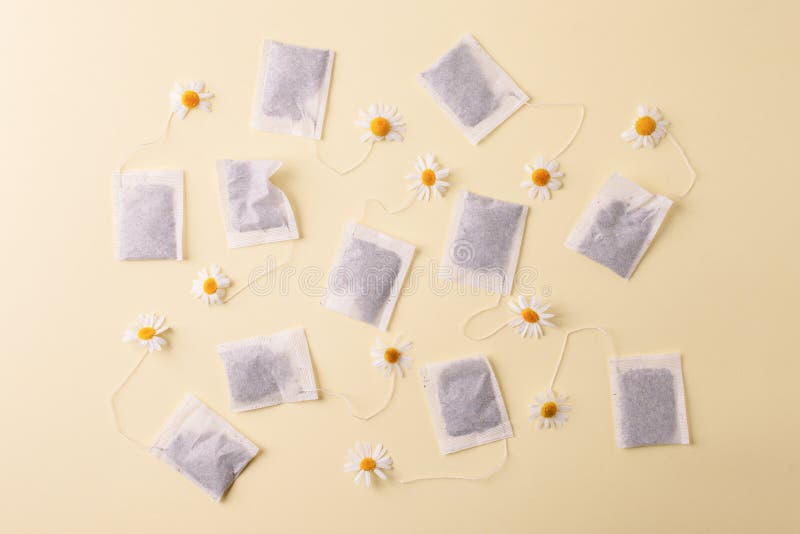 Kruiden alternatieve geneeskundereeks: Kamillebloemen en theezakjes op gele achtergrond Seizoengebonden anti-depressie, maag en stock foto Kruiden alternatieve geneeskundereeks: Kamillebloemen en theezakjes op gele achtergrond Seizoengebonden anti-depressie, maag en stock foto