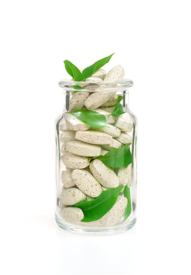Kruiden supplementpillen en verse bladeren in glas
