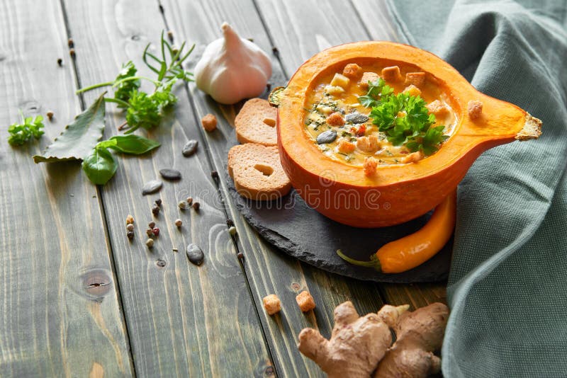 Kruidige die pompoensoep in een uitgeholde pompoen met ingrediënten wordt gediend royalty-vrije stock afbeeldingen Kruidige die pompoensoep in een uitgeholde pompoen met ingrediënten wordt gediend royalty-vrije stock afbeeldingen