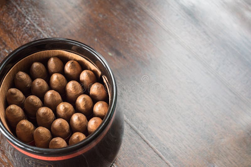 Close-up top view of a jar of cuban cigars on a hardwood table. Close-up top view of a jar of cuban cigars on a hardwood table