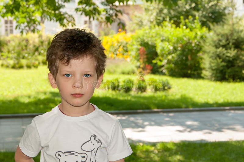 Krullend weinig jongen die dicht in de lens, in de zomer kijken stock foto's Krullend weinig jongen die dicht in de lens, in de zomer kijken stock foto's