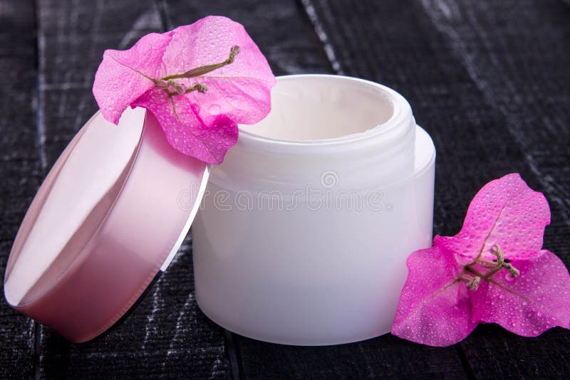 Krus av naturlig kräm med rosa blommor royaltyfri fotografi Krus av naturlig kräm med rosa blommor royaltyfri fotografi