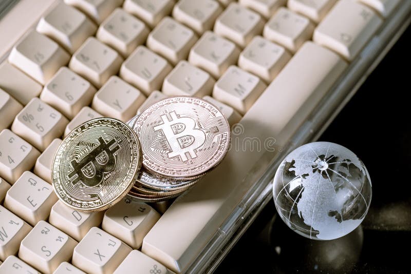 Kryptowaluta szklanego globu i bitmonety na klawiaturze. koncepcja biznesowa zdjęcia stock