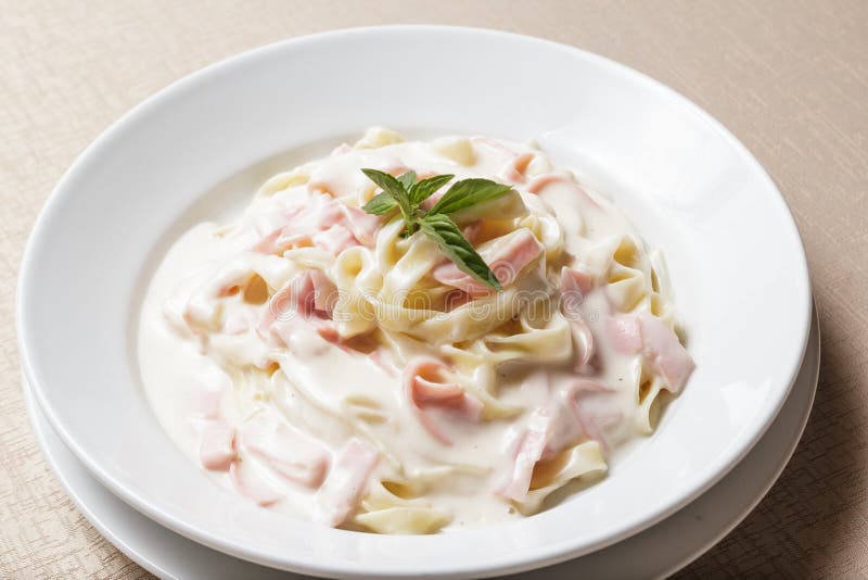 Krämig Fettuccine Pasta med skinka och parmesan royaltyfri foto Krämig Fettuccine Pasta med skinka och parmesan royaltyfri foto