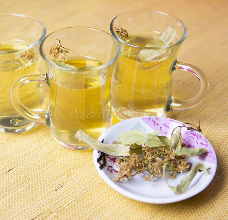 Kräuterlinden-Tee, entzündungshemmender Tee in Gläser Trockene Leinenblüte auf einer Untertasse lizenzfreies stockfoto
