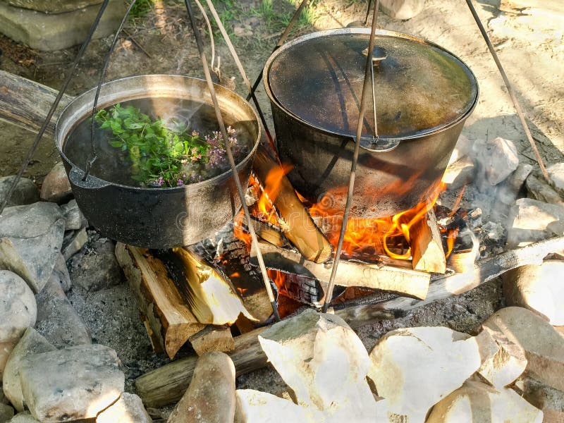 Kräutertee von den wilden Kräutern während des Kochens auf offenem Feuer stockfotografie Kräutertee von den wilden Kräutern während des Kochens auf offenem Feuer stockfotografie
