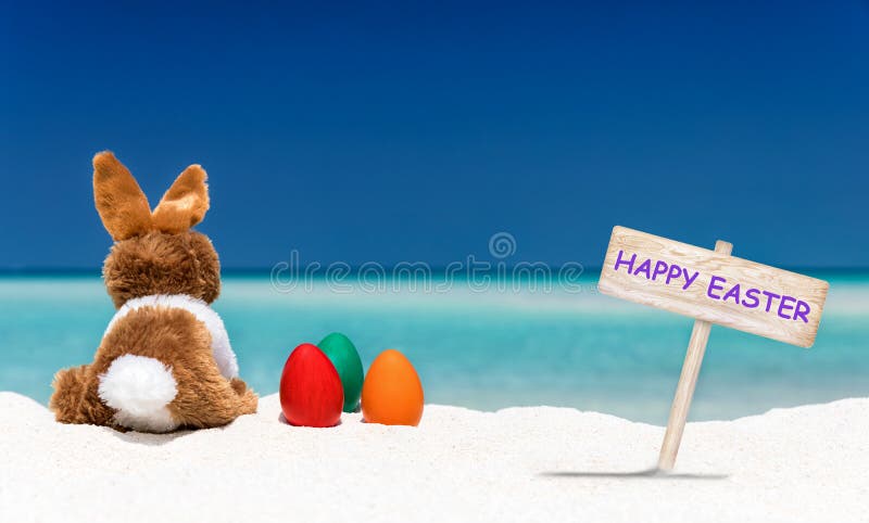 Królik, Easter jajka i Szczęśliwa wielkanoc, podpisujemy na plaży obraz royalty free Królik, Easter jajka i Szczęśliwa wielkanoc, podpisujemy na plaży obraz royalty free
