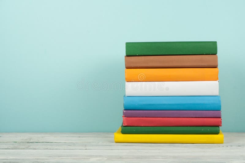 Ksi??kowa sterta, hardback kolorowe ksi??ki na drewnianym stole i b??kita t?o, tylna szko?y Odbitkowa przestrze? dla teksta Eduka fotografia stock Ksi??kowa sterta, hardback kolorowe ksi??ki na drewnianym stole i b??kita t?o, tylna szko?y Odbitkowa przestrze? dla teksta Eduka fotografia stock