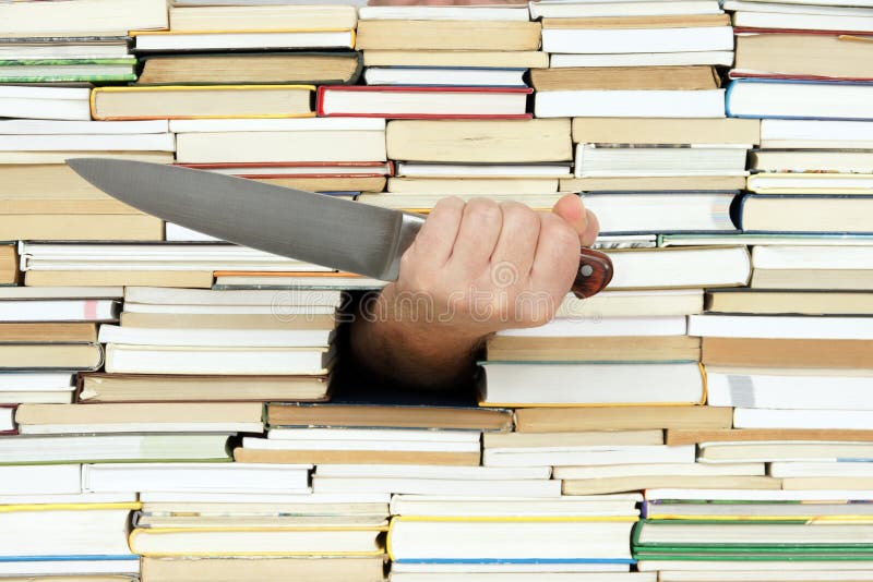 Big kitchen knife in hand on background of books. Big kitchen knife in hand on background of books