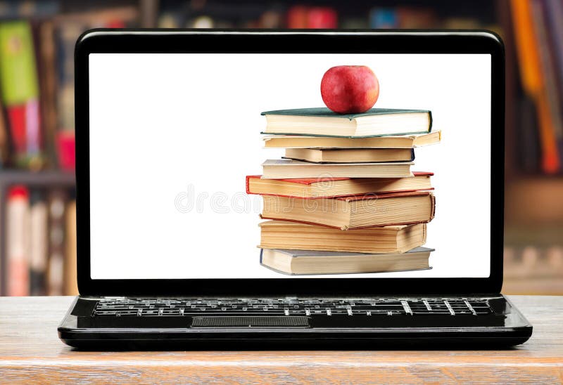 Książki i jabłko na laptopu ekranie obraz stock