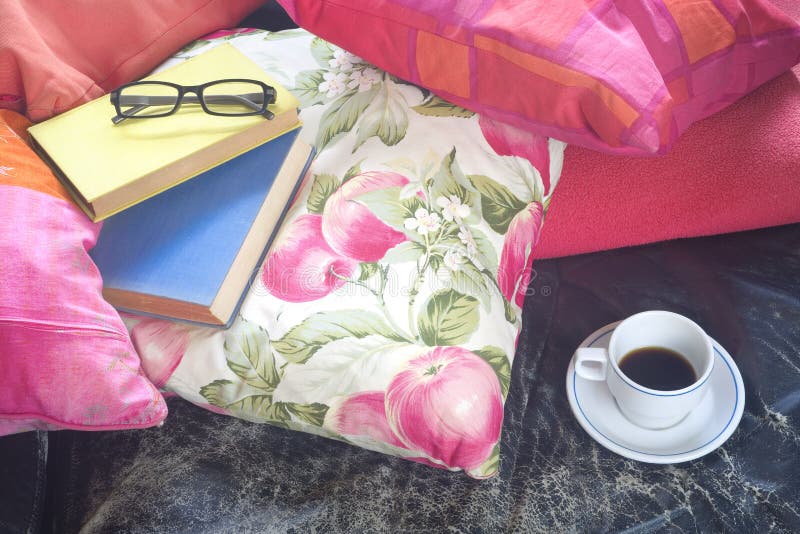 Książki na kanapie z filiżanką kawy i specs