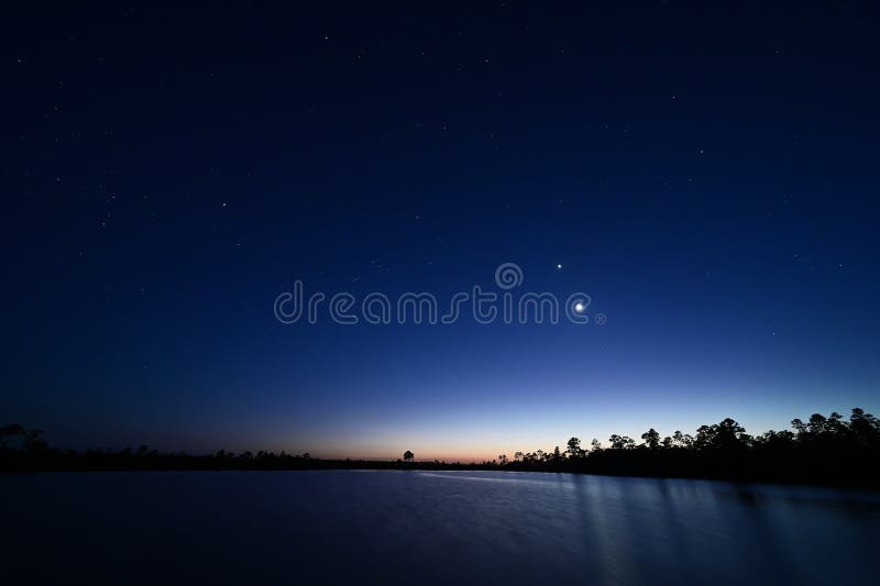 Księżyc venus orion nad sosnowym jeziorem w nocy zmierzchu. fotografia royalty free