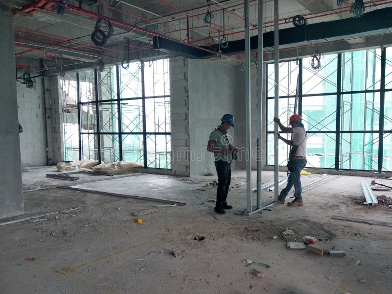 Drywall installation work in progress by construction workers at the construction site. stock photography Drywall installation work in progress by construction workers at the construction site. stock photography