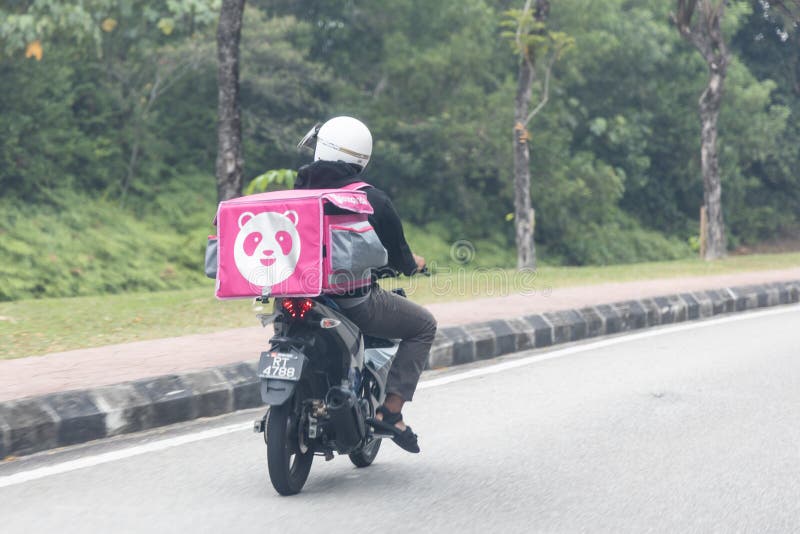 KUALA LUMPUR, MALAYSIA, September 17, 2019: Food order online via Foodpanda being delivered on motorbike by foodpanda rider.  Foodpanda is up coming online delivery company in Malaysia, app, application, asia, cashless, collaboration, convenience, service, digital, dinner, editorial, employment, job, lunch, motorcycle, people, phone, retail, services, technology, thermal, bag, transport, transportation