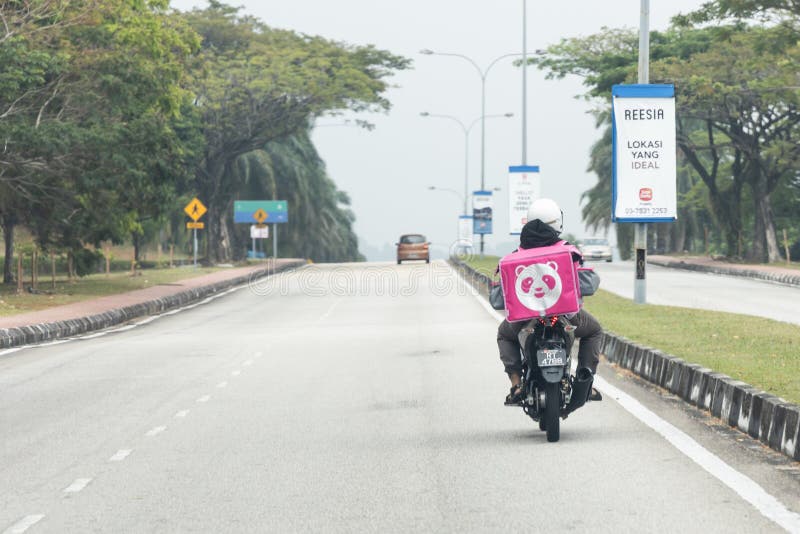 KUALA LUMPUR, MALAYSIA, September 17, 2019: Food order online via Foodpanda being delivered on motorbike by foodpanda rider.  Foodpanda is up coming online delivery company in Malaysia, app, application, asia, cashless, collaboration, convenience, service, digital, dinner, editorial, employment, job, lunch, motorcycle, people, phone, retail, services, technology, thermal, bag, transport, transportation