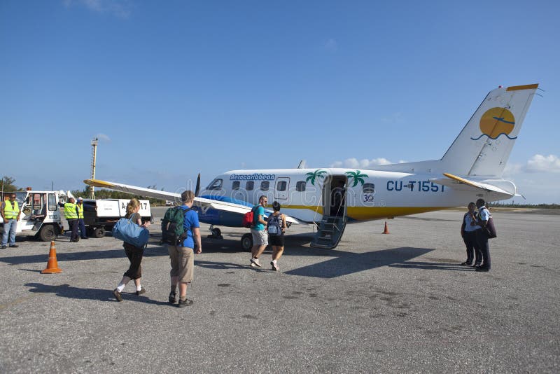 KUBA FEBRUARI 01, 2013: grupp av passageraren som stiger ombord det lilla flygplanet från ön till Varadero royaltyfri foto KUBA FEBRUARI 01, 2013: grupp av passageraren som stiger ombord det lilla flygplanet från ön till Varadero royaltyfri foto