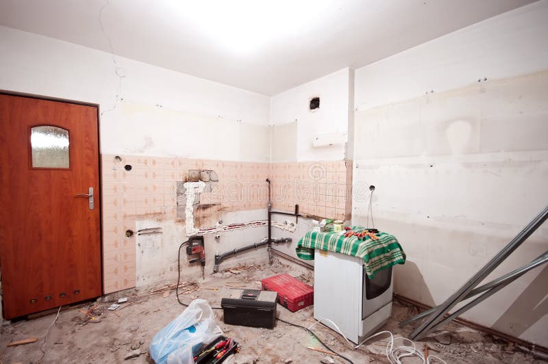 Early stage of a kitchen renovation process, removing old tiles and laying new plumbing. Early stage of a kitchen renovation process, removing old tiles and laying new plumbing.