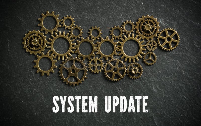 Cogwheels and the words `system update` on slate background symbolizing a complex system working together. Cogwheels and the words `system update` on slate background symbolizing a complex system working together