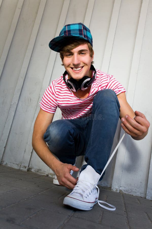Young man tying shoes and smiling. Young man tying shoes and smiling
