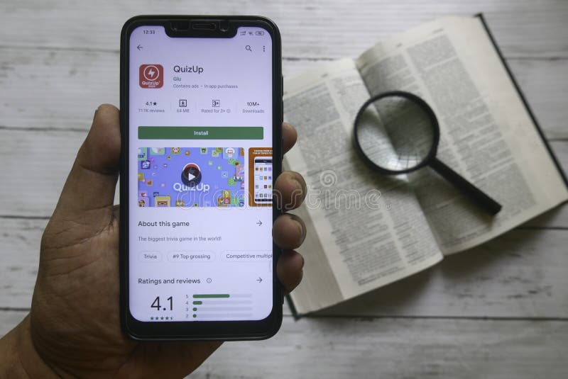 KULIM,MALAYSIA - APRIL 8TH,2020 : Top view of a hand holding a smartphone with an android apps of Quizup royalty free stock images