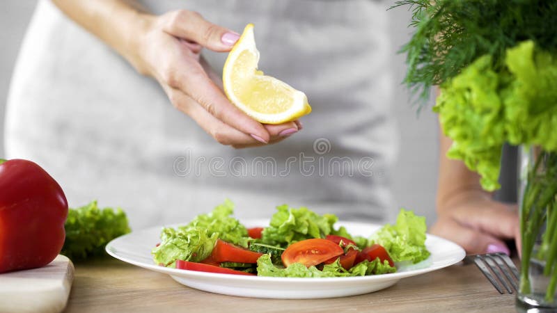 Kulinarny damy mienia cytryny kawałek dla sałatkowego opatrunku, kalorie ograniczenie, świeża żywność zdjęcia stock Kulinarny damy mienia cytryny kawałek dla sałatkowego opatrunku, kalorie ograniczenie, świeża żywność zdjęcia stock