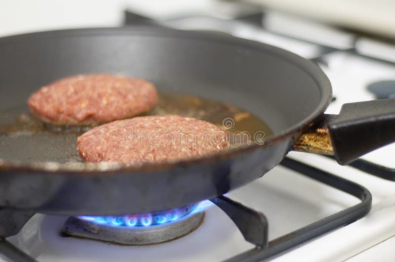 Cooking meat on a stove. Cooking meat on a stove