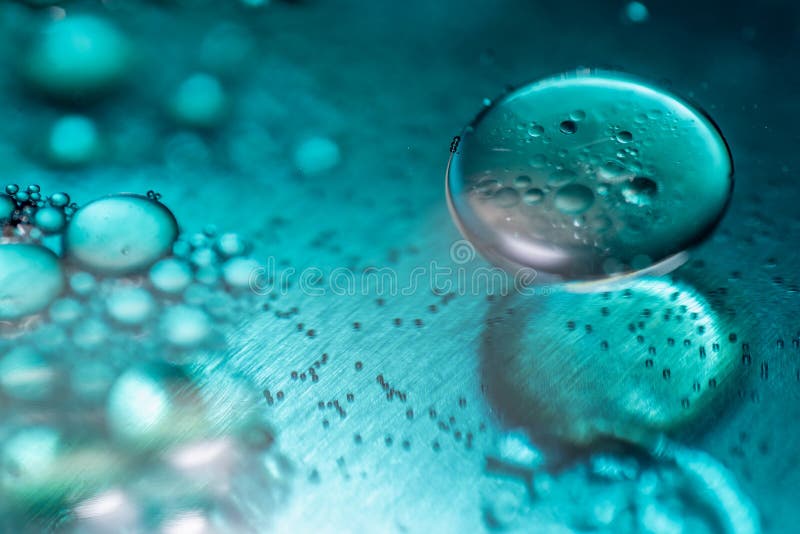 Kulör olja tappar och bubblar på en yttersida för metallkugghjulmotor Bred vinkel Lens som täckas av det Lens locket i mitt royaltyfria bilder Kulör olja tappar och bubblar på en yttersida för metallkugghjulmotor Bred vinkel Lens som täckas av det Lens locket i mitt royaltyfria bilder