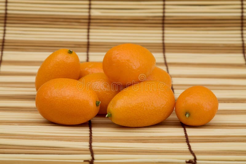 Kumquat fresco contro una stuoia