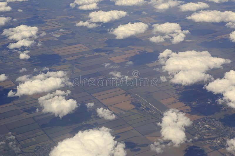 Kumuluswolken über den Feldern von der Flugzeugansicht