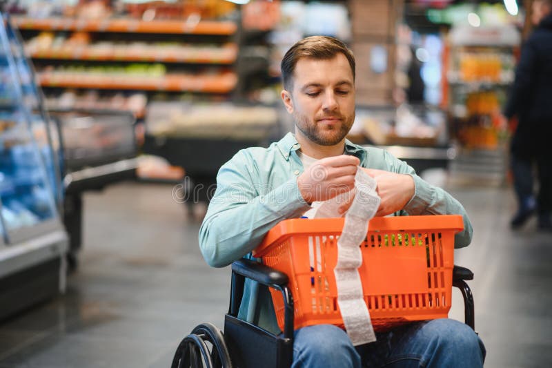 Kunde im Rollstuhl überprüft Lebensmittelgeschäft Eingang im Supermarkt stockfoto